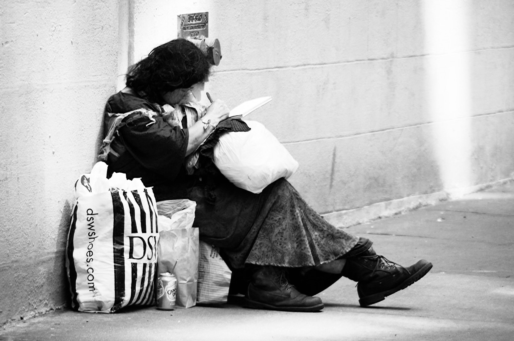 Person sitting on a city sidewalk